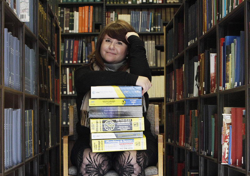 Emily Goodmann sits with a stack of phone books, the subject of her dissertation as a doctoral student, in the Northwestern University Library in Evanston, Ill. Goodmann says white pages directories should be archived for historical purposes.