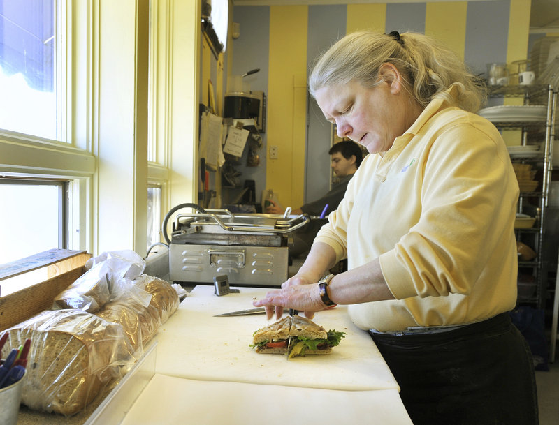 Jane Chilton cuts a sandwich she had just prepared for a customer at Market Day sandwich shop in Kennebunk. Chilton and her partner, Peggy Wagor, own the popular shop, which also features a good selection of cheeses and wines.