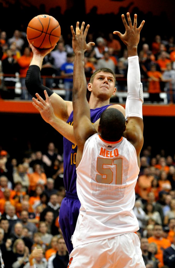 Austin Pehl of Northern Iowa lifts a shot over Fab Melo of Syracuse during the first half of Syracuse’s 68-46 victory Friday night in a college basketball opener.