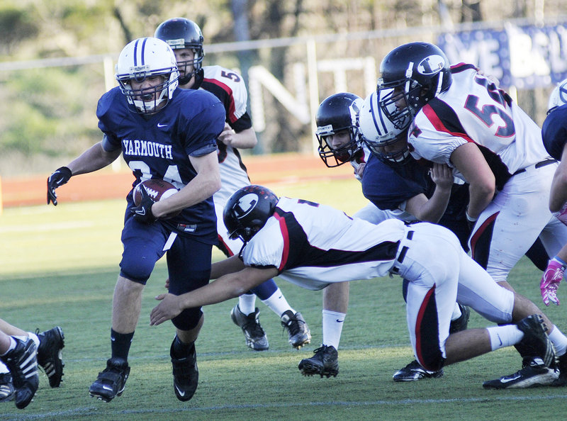 Anders Overhaug, who gained 109 yards on 15 carries for Yarmouth, attempts to slip past Mike McNamara of Lisbon during their Western Class C championship game Saturday at Yarmouth High. Yarmouth won 14-12 and will play Stearns for the state championship next Saturday in Portland.