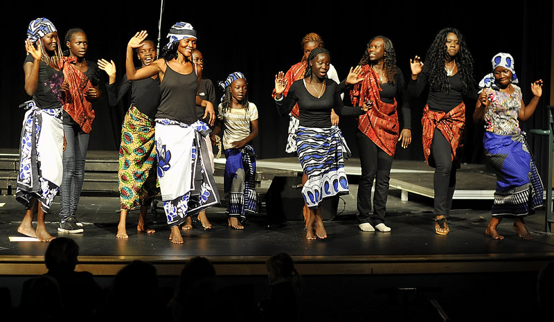 Members of Malika, a Sudanese group, perform a traditional dance during “Our Global Beat,” an international concert at Falmouth High School on Saturday. Malika means “angel” in Swahili.