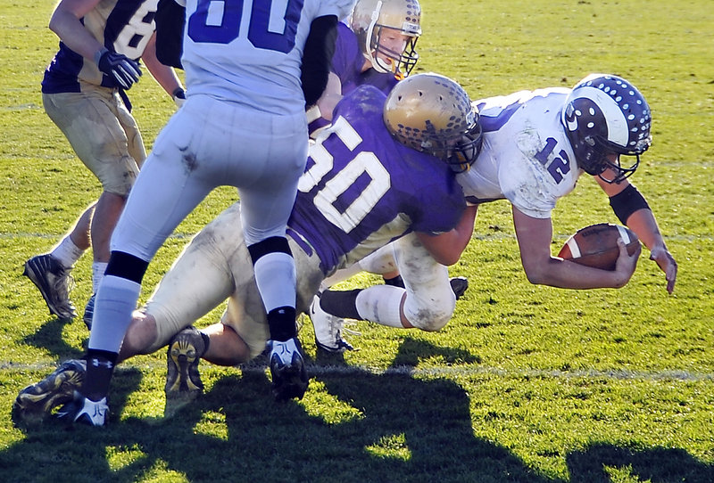 Cheverus linebacker Zach Dulac takes down Deering quarterback Jamie Ross during a thrilling Western Class A final at Cheverus on Saturday. The Stags won, 35-34.