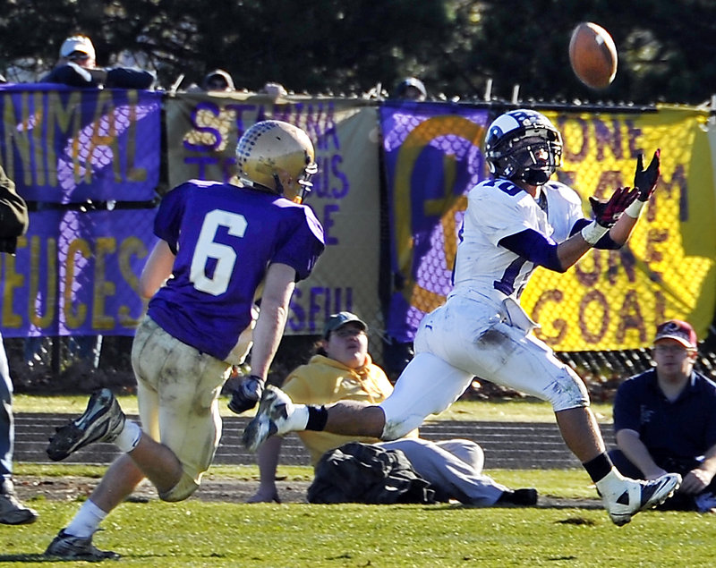 Renaldo Lowry of Deering hauls in a pass from Jamie Ross, behind Peter Gwilym of Cheverus. The play turned into a 60-yard touchdown.