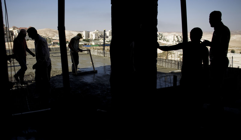 Palestinian men work on a construction site in the West Bank Jewish settlement of Maale Adumim, near Jerusalem. Israel’s prime minister briefed his Cabinet on Sunday on a package of security and diplomatic incentives the United States has proposed.