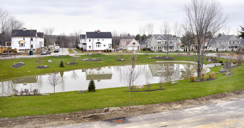 New and existing housing units are reflected in a pond at Dunstan Crossing in Scarborough. It s a viable alternative for people who want to live in a place that integrates housing density, open space and a walkable community, but don't want to live downtown, one expert said.