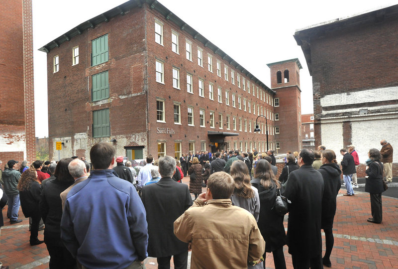 A crowd of residents, officials and business people attends an open house for The Mill at Saco Falls, a 66-unit mixed-income residential development in a refurbished mill building in Biddeford, on Monday.