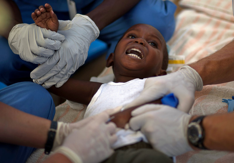 A child with cholera symptoms is treated Monday by volunteer American doctors at a hospital in Archaie, Haiti. Nearly 1,000 people have been killed and more than 16,000 have been hospitalized for cholera across the nation.