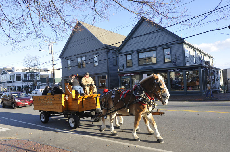 Bells jingle as a pair of Belgians from Meadow Creek Farm pull a wagonful of passengers down Freeport's Main Street on Saturday.