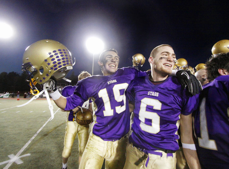 Cheverus High School's undefeated Stags, including an elated Louie DiStasio, left, and Peter Gwilym, celebrate another victory Saturday, grabbing the Class A state championship over Bangor, 46-8.