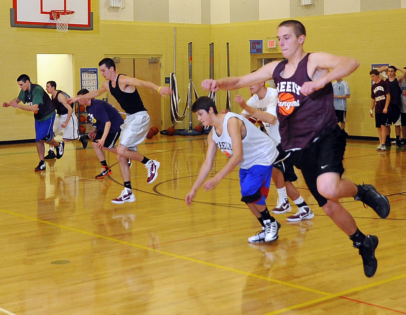 Caleb King, right, leads candidates for Greely’s boys’ basketball teams through an agility drill during the first day of official team practice Monday in Cumberland.