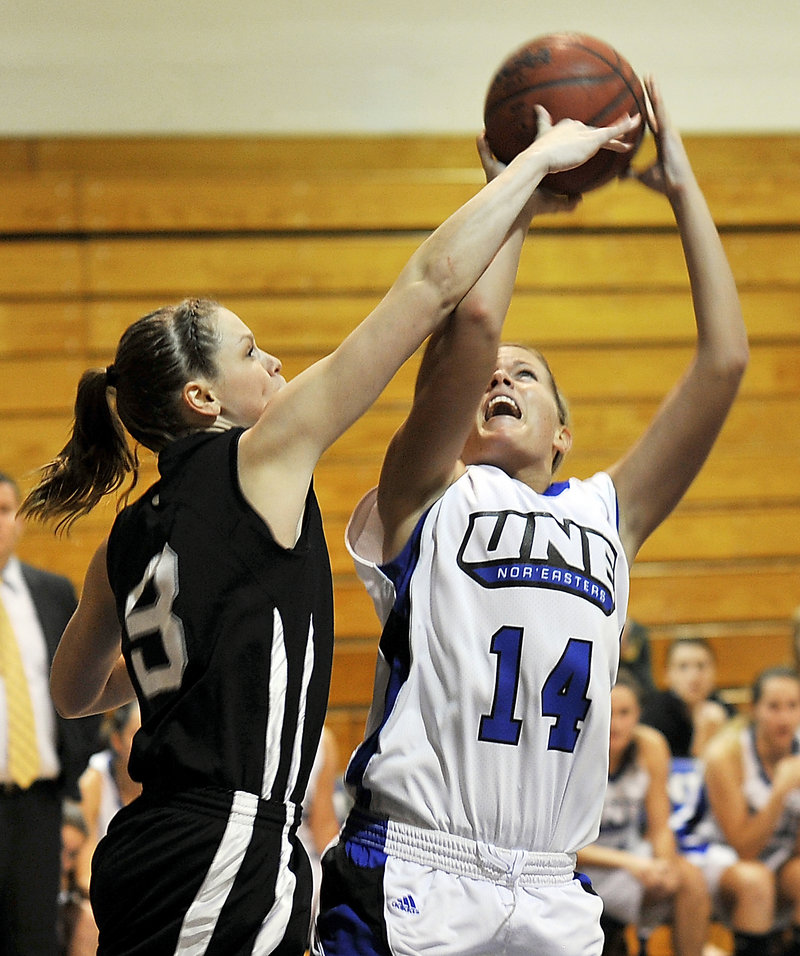 Amy Hackett of Bowdoin, left, blocks a shot by Kelley Paradis of the University of New England during their women’s basketball game Tuesday night. Bowdoin’s defense led the way to an 82-55 victory.
