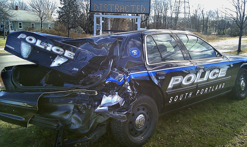 South Portland police have placed this wrecked cruiser at the corner where the Casco Bay Bridge meets Broadway to send a message about distracted driving. Police say the cruiser was parked on the bridge when it was struck by a pickup truck whose driver was talking on his cell phone.