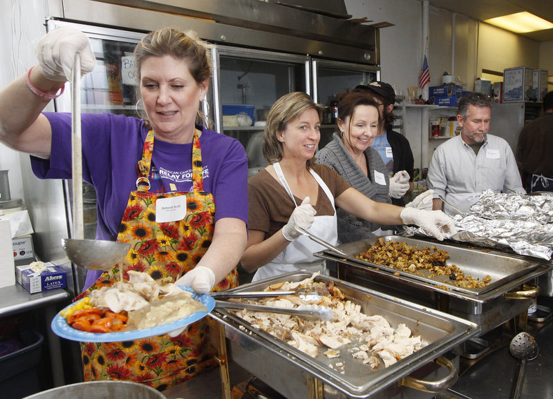 Deborah Scott of Porter serves up a heaping dish of food at the Portland Club, where the United Way of Greater Portland sponsored a community dinner on Thanksgiving Day.