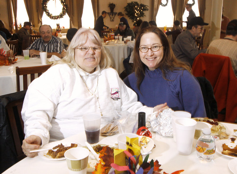 Sandra McCann, left, and Jewelz Dellger, both of Portland, enjoy Thanksgiving dinner at the Portland Club on Thursday.