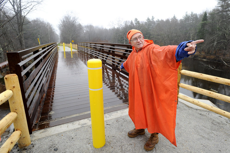 John Andrews points toward Kennebunk as he shows off a new section of the Eastern Trail in Arundel where it crosses the Kennebunk River with a new bridge. The trail is part of the 3,000-mile East Coast Greenway.