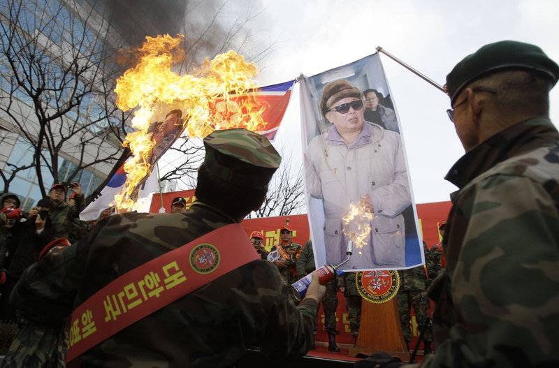 South Korean former marines burn images of North Korean leader Kim Jong Il, right, and his son Kim Jong Un during a rally denouncing North Korea, Saturday in Seoul.