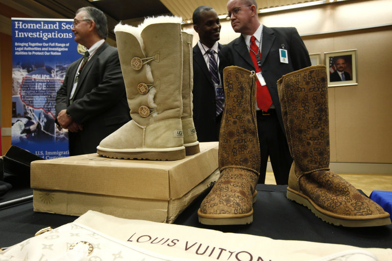 Fake Ugg brand boots are displayed at the Justice Department in Washington during Monday's news conference with Attorney General Eric Holder about seizures of websites involved in the illegal sale of counterfeit goods and copyrighted works.