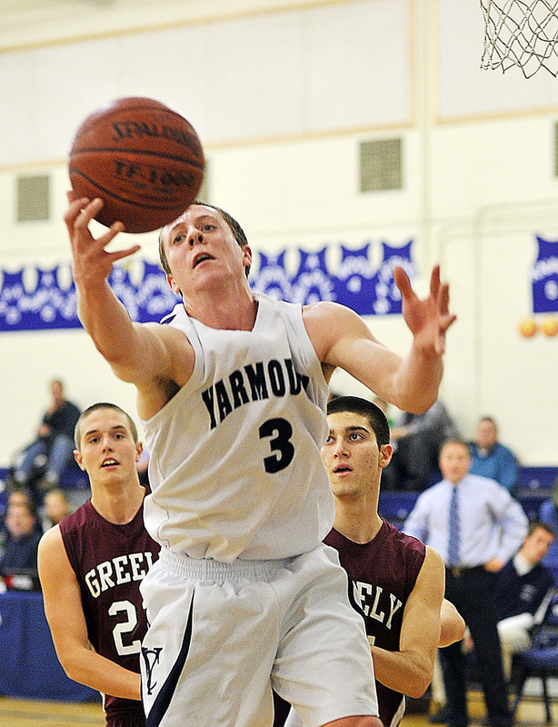 Josh Britten of Yarmouth, who led all scorers with 21 points, reaches for a rebound in front of Caleb King, left, and Jake Levite during the first half of Greely’s 61-53 win Monday at Yarmouth.