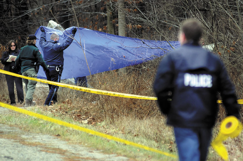 Police cover human remains discovered Sunday morning by Game Wardens off Outer Winthrop Street in Hallowell. Wardens, searching with dogs, located the body just after noon near the granite quarries.