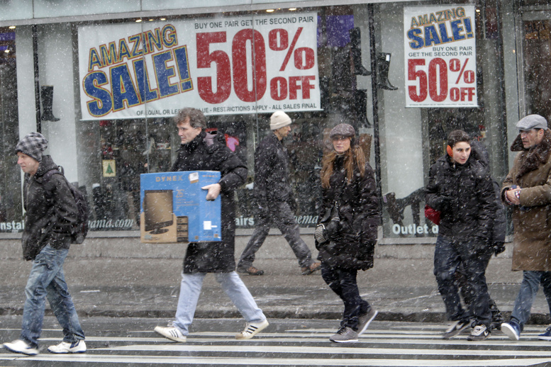 Shoppers make their way in the snow in Union Square today in New York.