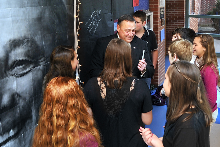 Gov.-elect Paul LePage visits Lyman Moore Middle School in Portland and talks with students after signing the wall next to a large photo of himself.