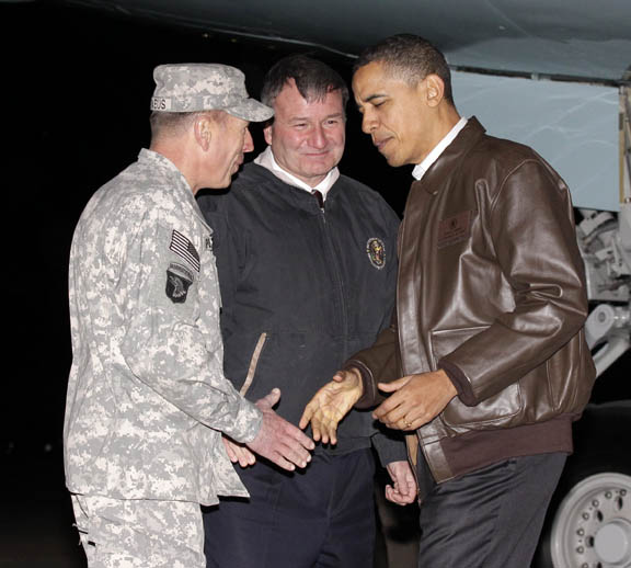President Barack Obama is greeted by NATO Commander in Afghanistan Gen. David Petraeus, left, and U.S. Ambassador to Afghanistan Karl W. Elkenberry, center, after stepping off Air Force One during an unannounced visit to Bagram Air Base today.