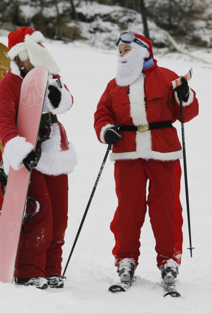 Lynn Philippone, right, speaks with Amy Bloodgood, left, Sunday during the 11th annual Santa Sunday at Sunday River in Newry, Maine. Participants get a free lift ticket if they dress as Santa and donate $10 or more to the Bethel Rotary Club's annual toy drive.