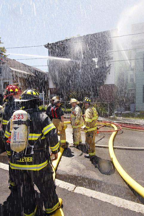 In this May 2009 photo, firefighters pour water onto an apartment building at 8 Kossuth St. in Biddeford that was heavily damaged during a fire that left its occupants homeless. Police say Edna Godin, an occupant at the time, has confessed to starting the fire.