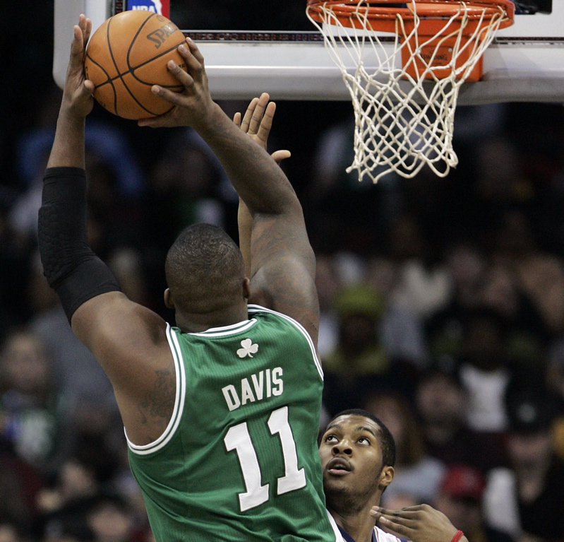 Glen Davis of the Celts takes a jump shot as New Jersey's Derrick Favors defends in the first half today at Prudential Center in Newark , N.J. The Celts won, 100-75.