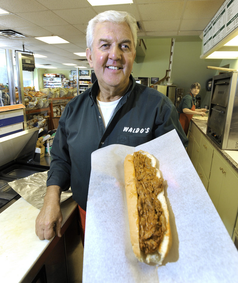 Jerry Williams displays a pulled pork sandwich at Waldo's General Store in Falmouth.