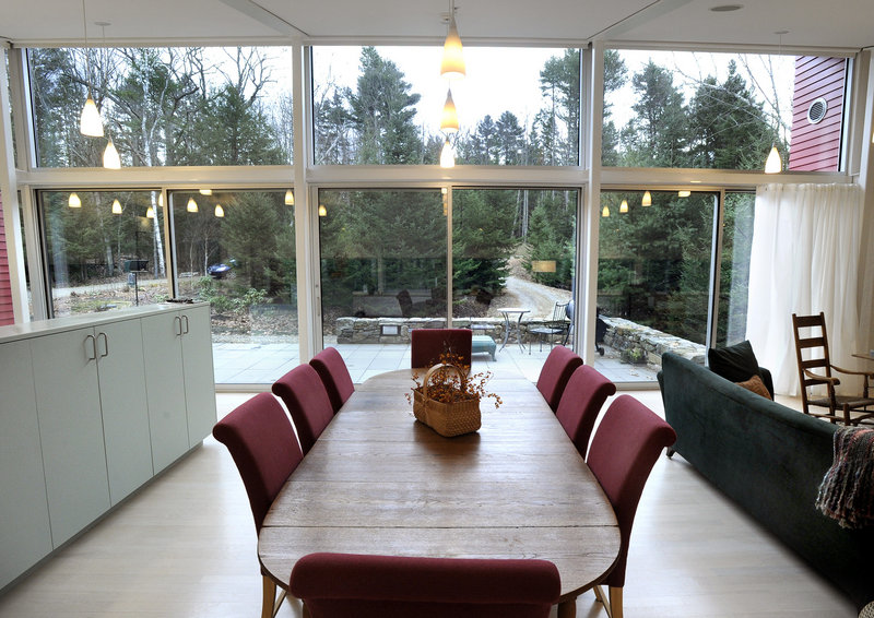 The dining area of Jane and Robert Weir’s home in West Bath faces a solid wall of glass that brings in lots of light and encourages the feeling of coexisting with nature.
