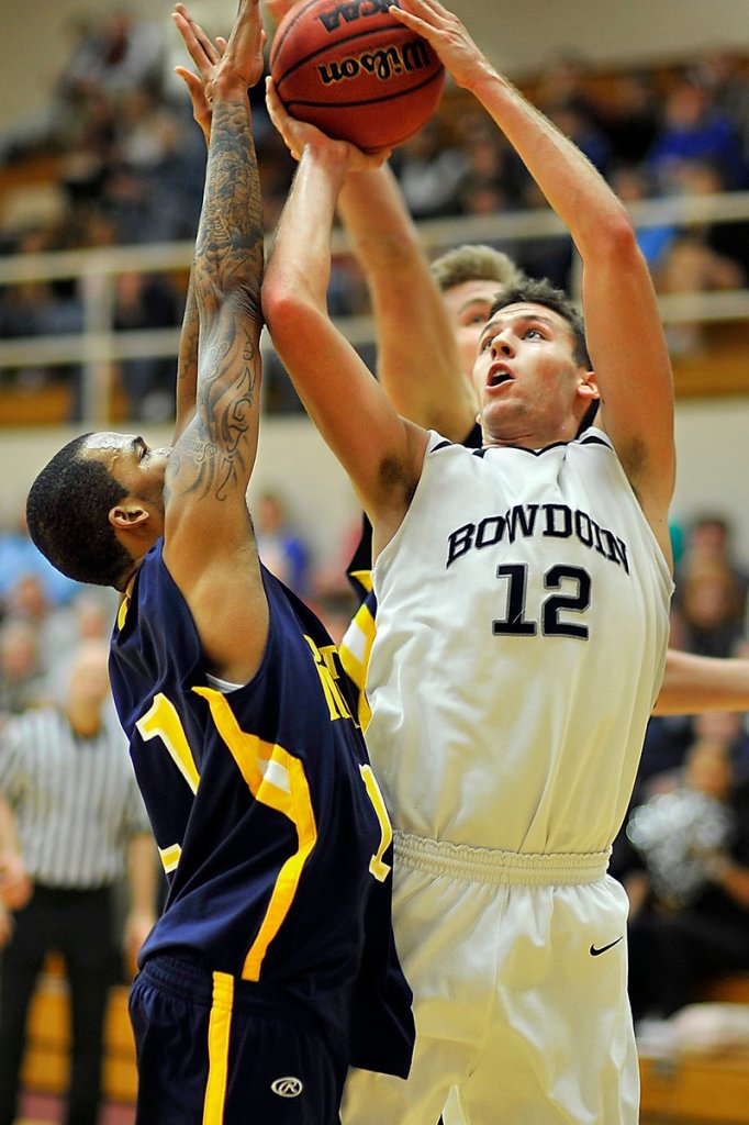 Andrew Madlinger, right, of Bowdoin goes back up with a rebound to score over Southern Maine’s Corteze Isaac during a men’s basketball game Tuesday night in Brunswick. USM took a 70-68 victory.