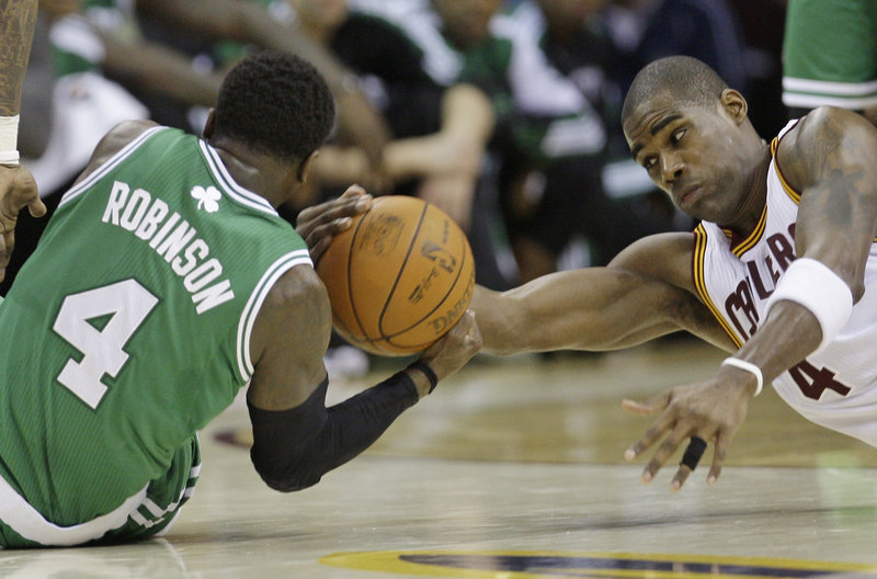 Boston’s Nate Robinson and Cleveland’s Antwan Jamison fight for the ball in the fourth quarter Tuesday night. The Celtics held the Cavs to 39 percent shooting.
