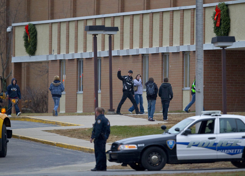 Students arrive for class at Wisconsin’s Marinette High School as police stand guard outside Wednesday.