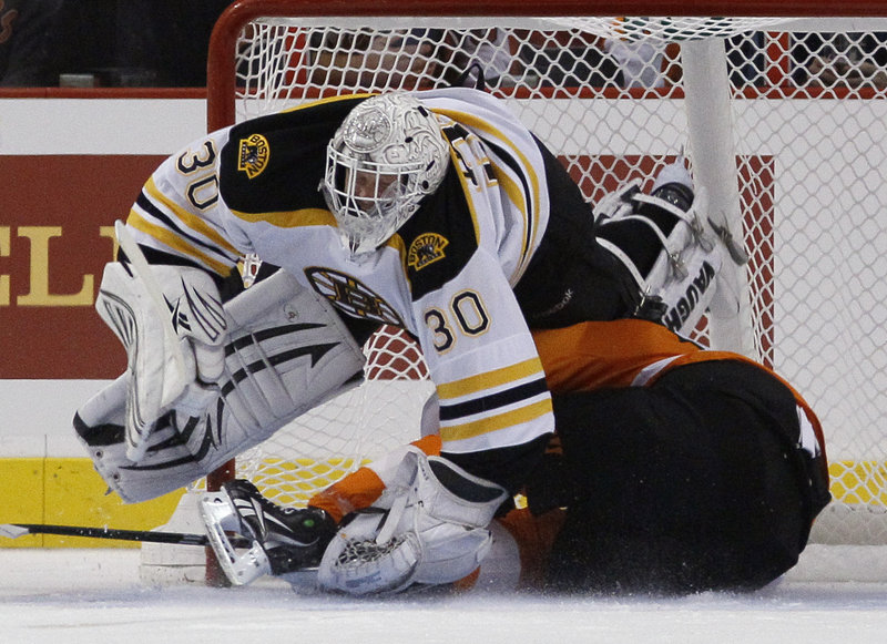 Bruins goalie Tim Thomas keeps the puck and the Flyers’ Scott Hartnell out of the net in the first period Wednesday night in Philadelphia. Thomas later stopped Hartnell’s penalty shot and made 41 saves in all for Boston.