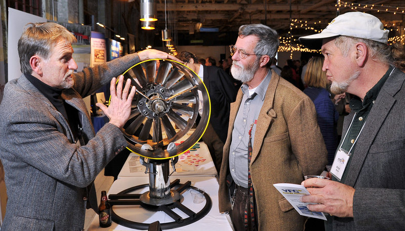 Benjamin Brickett, left, of VFG Energy Systems in Kittery demonstrates a prototype water turbine to Phineas Sprague Jr., center, and Michael Mayhew, a renewable energy consultant, during an event in Portland on Wednesday honoring Maine Technology Institute. Located in Gardiner, MTI was celebrating 10 years of recognizing companies that invest in and market Maine’s innovation economy.