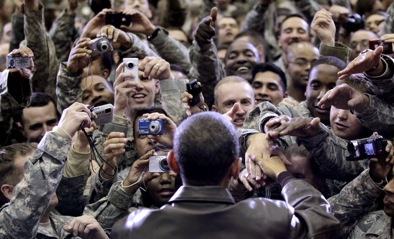 President Obama greets military personnel at a rally during a surprise visit Friday at Bagram Air Force Base in Afghanistan. He told troops they’re breaking the Taliban’s momentum.