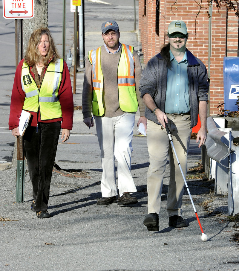 Reporter Ray Routhier, center, shadows Caitlyn Blodget as she instructs Wayne Lawson of Portland, who is visually impaired, how to get around outdoors using a cane.