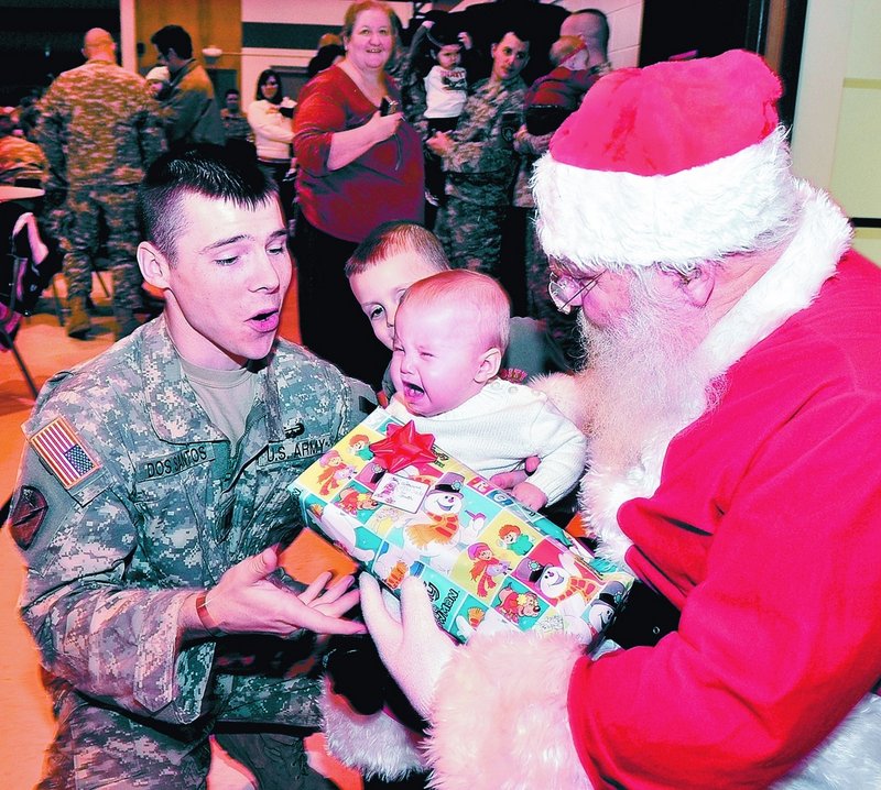 Maine Army National Guard Capt. Eric Dos Santos consoles his daughter Catherine, who cried while sitting on Santa’s lap during a Christmas party Sunday at the Waterville Armory.