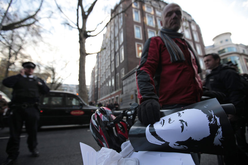 A supporter of WikiLeaks founder Julian Assange, holding a poster with Assange’s image on it, gathers with others outside the City of Westminster Magistrates Court in London where Assange’s case was heard on Tuesday.