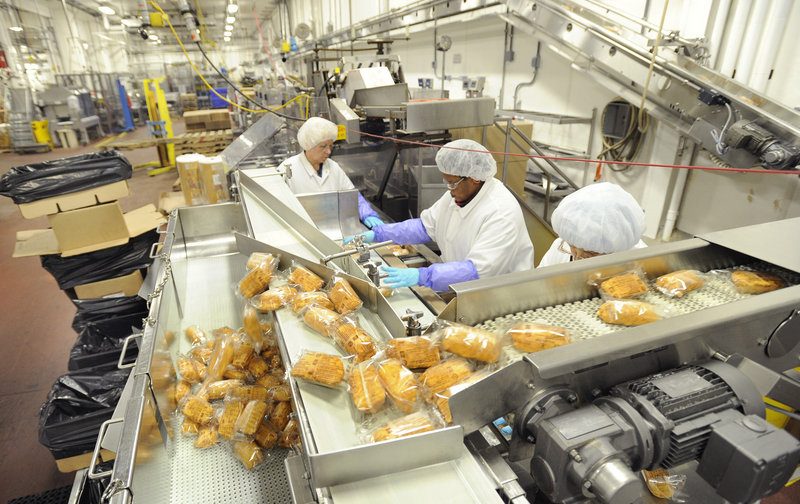 Workers at AdvancePierre's Portland plant  package stuffed chicken breasts along a production line in May 2014. The frozen entree division has become one of the most profitable for the company.