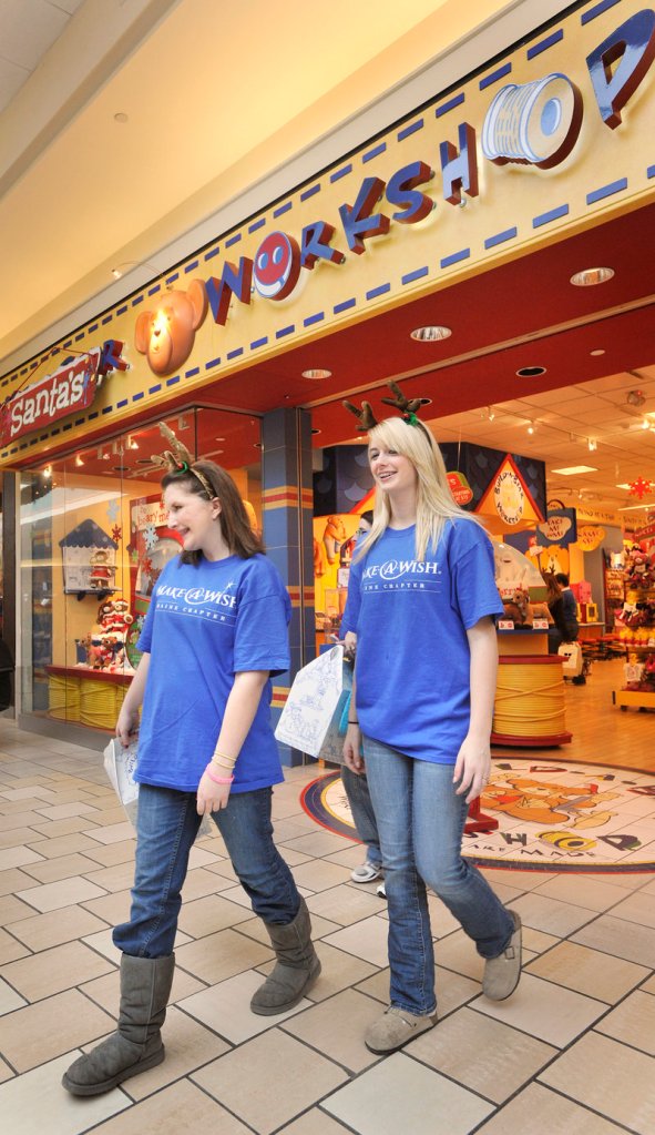Nicole Guerrette, left, leaves the Santa’s Workshop store at the Maine Mall with her cousin, Courtney Perry, during Friday’s shopping spree. “They have done so much for me,” Guerrette says of the Make-A-Wish Foundation. “I want to do something for them after this is all over.”