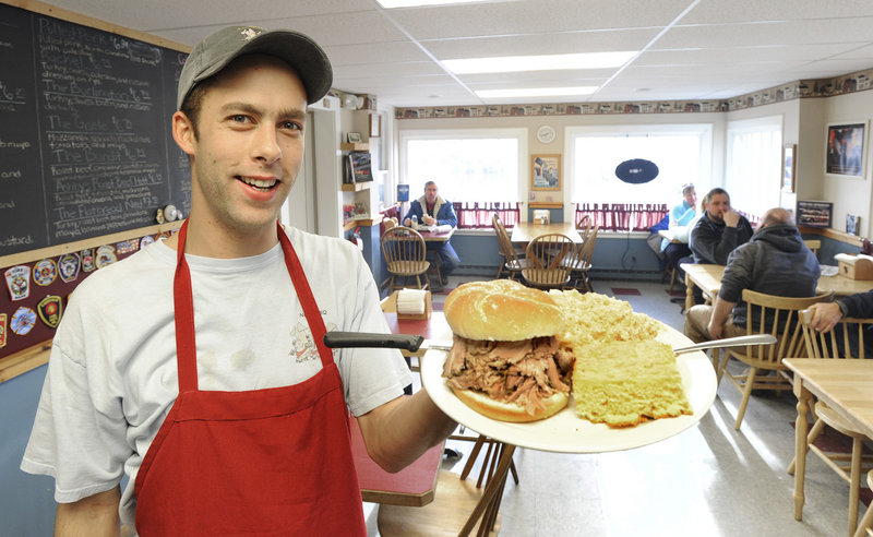 Ben Schmidt serves a pulled pork sandwich plate at Ashby s Deli.