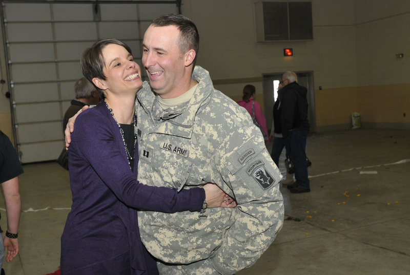 Capt. Paul Bosse of Auburn is reunited with his wife, Loriann, in Bangor on Thursday when he and the Maine Army National Guard company he commands returned from Afghanistan.