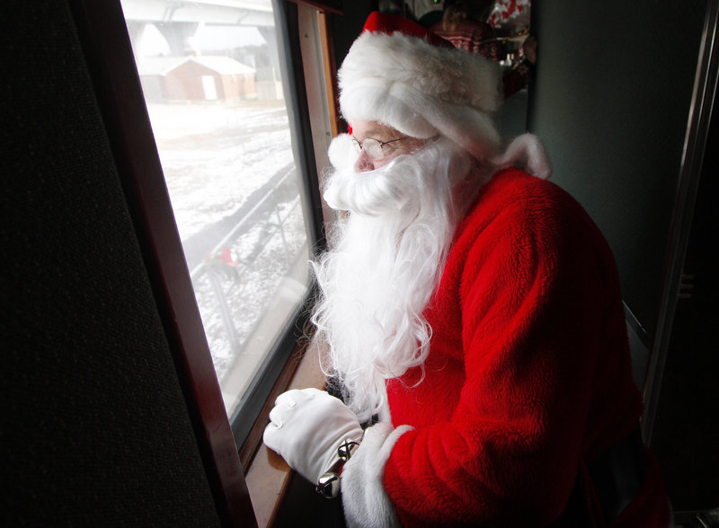 Santa Claus finds a quiet spot to watch the children board, so he can surprise them during the ride.