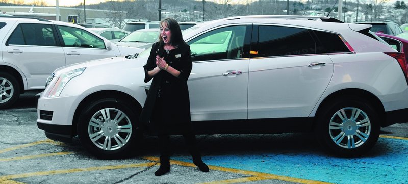 Julie Peacock of West Gardiner celebrates last week at O’Connor Motors in Augusta while picking up her sixth free car as an independent sales director for Mary Kay cosmetics.