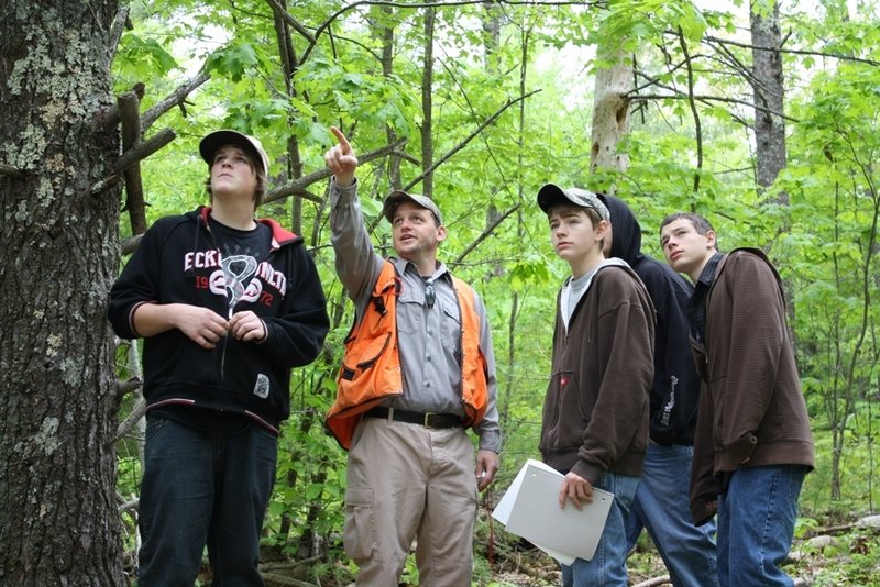 Lake Region High School students and Ken Canfield, pointing, of the Maine Forest Service study the Mayberry Hill Preserve, a 160-acre tract in Casco, during a trip last year.