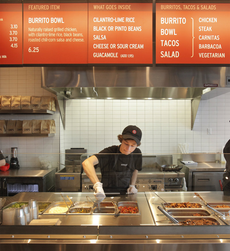 Kyle Braley stirs a tomatillo green chili salsa at the new Chipotle Mexican Grill in South Portland on Monday, as the franchise restaurant held a “soft opening” for invited customers. The restaurant’s grand opening is today.