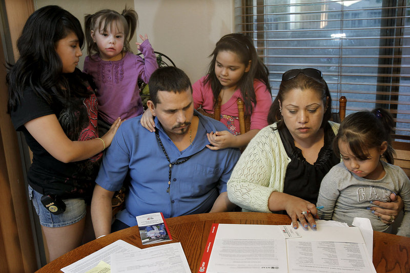 Francisco Felix, 32, is surrounded at home in Laveen, Ariz., by his family – daughters Carmen, 12, Carla, 2, Jessica, 10, Jennifer, 3 1/2, and his wife, Flor, as they fill out paperwork for the National Transplant Assistance Fund. In November, Francisco had been ready to get a lifesaving liver transplant, but had to cancel the surgery when the family could not raise the $500,000 needed. Flor is one of dozens of Arizona patients who need liver transplants but can’t get them because of budget cuts to the state’s Medicaid system.