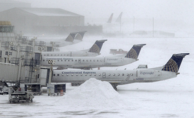 Blowing snow obscures Continental Express jets at their gates Monday at Cleveland Hopkins International Airport. Ohio airports reported scattered delays and cancellations due to a winter storm that has pummeled a broad area of the Midwest.